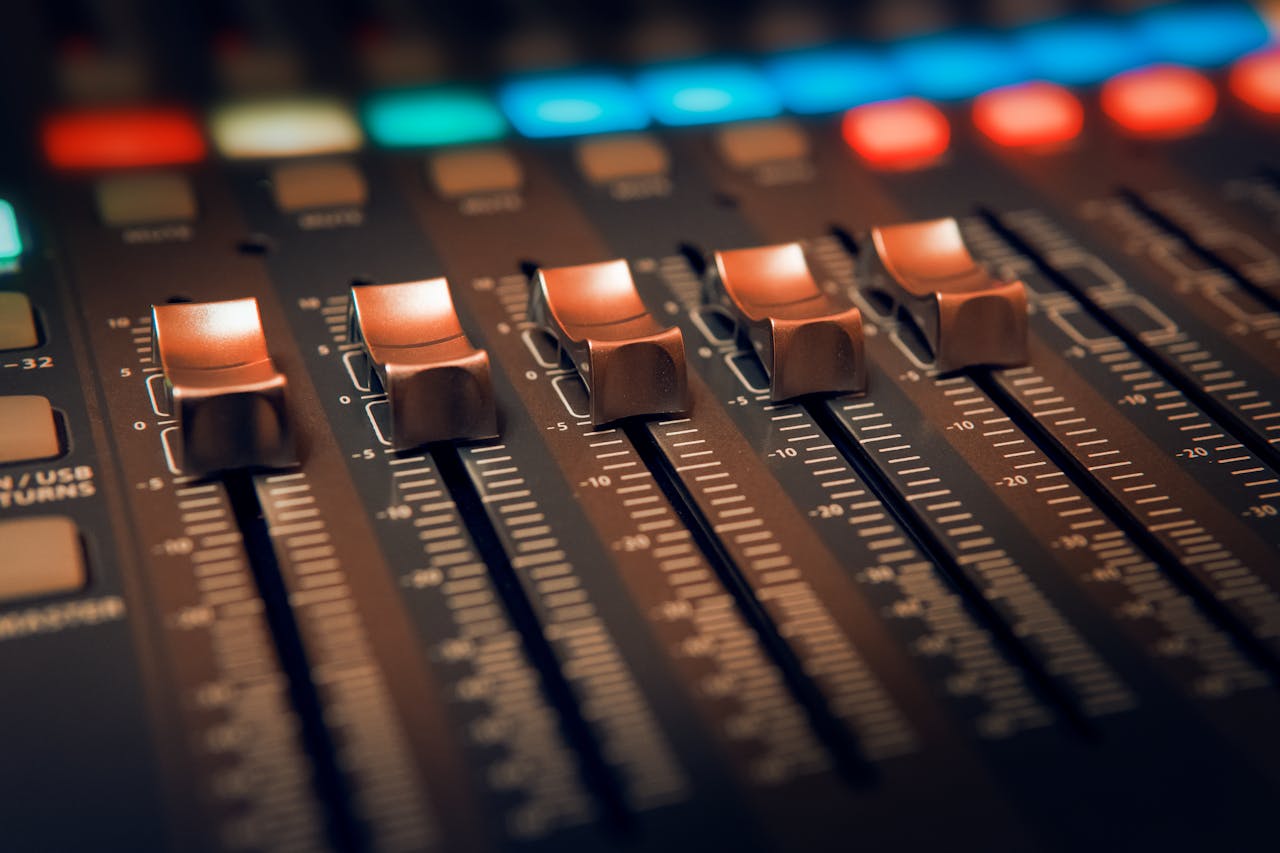 Professional audio mixing console with illuminated faders for precise sound control.