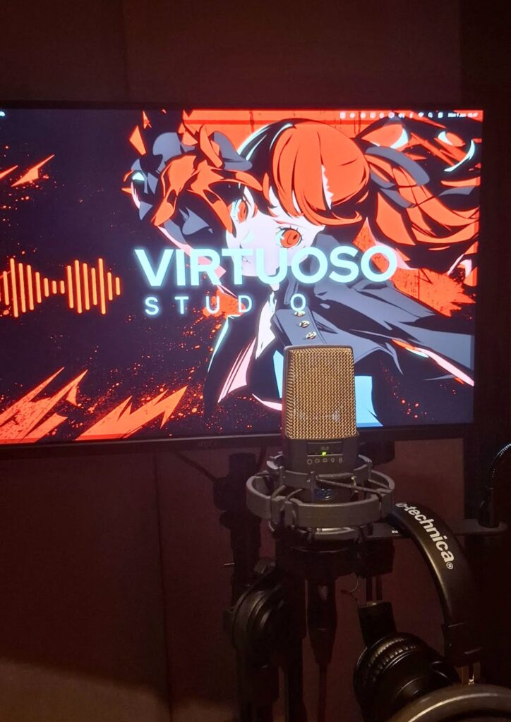 Professional studio microphone in front of a monitor displaying Virtuoso Studio branding.
